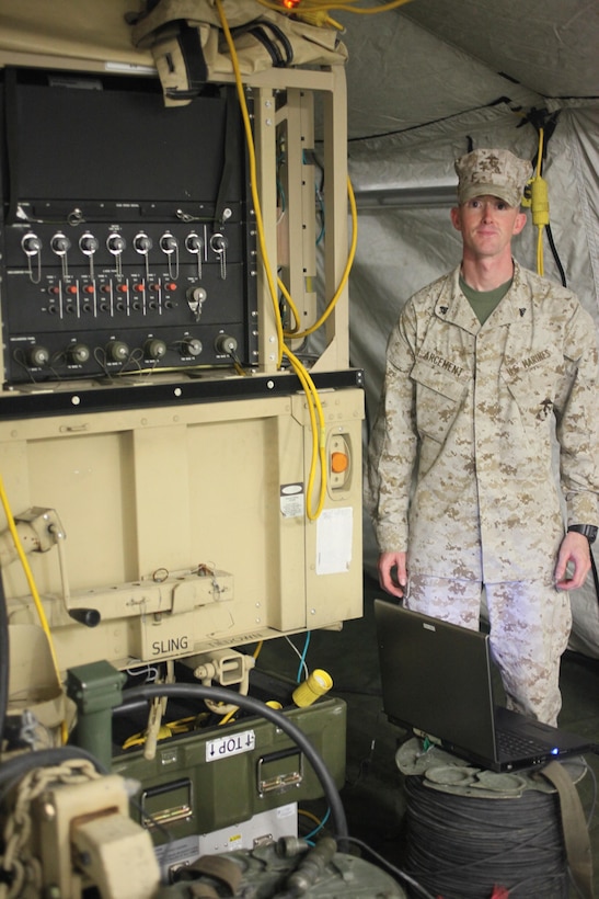Cpl. Alvin P. Arcement, a cyber network operator with Marine Wing Support Squadron 271, stands next to a routing network aboard Marine Corps Air Station Cherry Point, N.C., July 15. Arcement oversees and maintains the battlefield internet and manages access rights while in the field.    