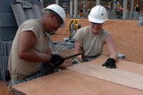 Sgt. 1st Class Brandon Cabanilla of Kahalui, Hawaii and Pvt. 1st Class Michelle Almeida of Kihei laugh as they prepare the frames for the windows in the new classroom facility the Hawaii National Guard, 230th Engineer Company, Vertical is building jointly with the Royal Thai Marine Engineer Battalion during the Cobra Gold joint engineering civil assistance mission hosted at the Ban Nong Buatong school in the Chanthaburi District of Thailand Jan. 24 to Feb. 11.