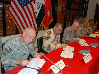 U.S. and Iraqi officials sign a certificate of agreement at the Gulf Region Division headquarters in Baghdad, Feb. 12, 2009, signaling design approval for the $53 million Umm Qasr pier and seawall project.