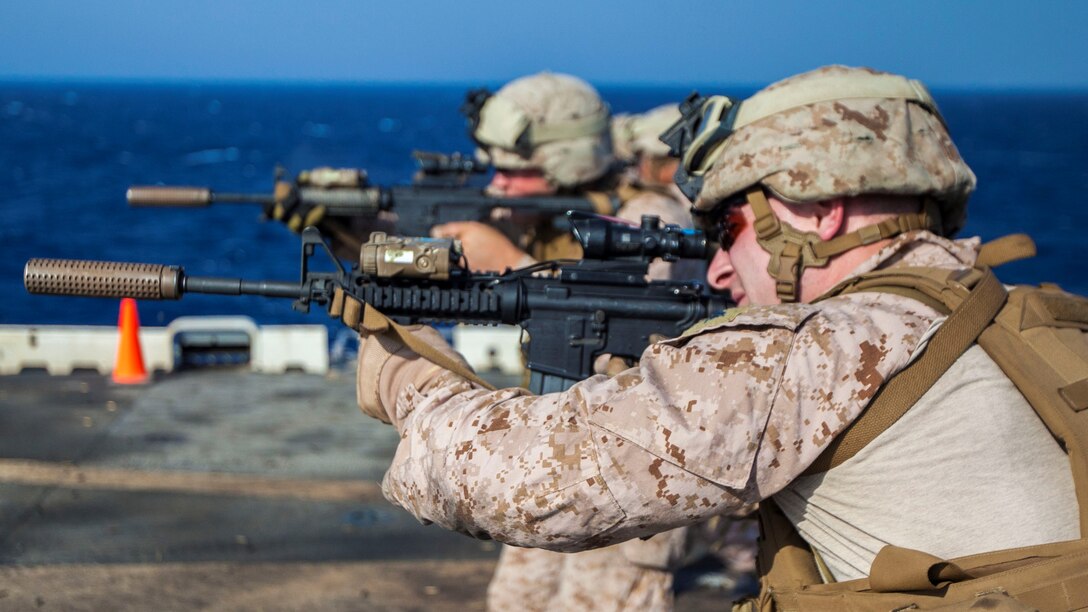 U.S. Marines assigned to Scout Sniper Platoon, Battalion Landing Team 3/2, 26th Marine Expeditionary Unit (MEU), conduct an M4 Carbine live-fire exercise on the flight deck of the USS Kearsarge, at sea, July 18, 2013. The 26th MEU is a Marine Air-Ground Task Force forward-deployed to the U.S. 5th Fleet area of responsibility aboard the Kearsarge Amphibious Ready Group serving as a sea-based, expeditionary crisis response force capable of conducting amphibious operations across the full range of military operations. (U.S. Marine Corps photo by Sgt. Christopher Q. Stone, 26th MEU Combat Camera/Released)