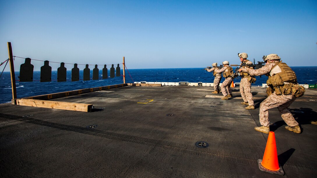U.S. Marines assigned to Scout Sniper Platoon, Battalion Landing Team 3/2, 26th Marine Expeditionary Unit (MEU), conduct an M4 Carbine live-fire exercise on the flight deck of the USS Kearsarge, at sea, July 18, 2013. The 26th MEU is a Marine Air-Ground Task Force forward-deployed to the U.S. 5th Fleet area of responsibility aboard the Kearsarge Amphibious Ready Group serving as a sea-based, expeditionary crisis response force capable of conducting amphibious operations across the full range of military operations. (U.S. Marine Corps photo by Sgt. Christopher Q. Stone, 26th MEU Combat Camera/Released)