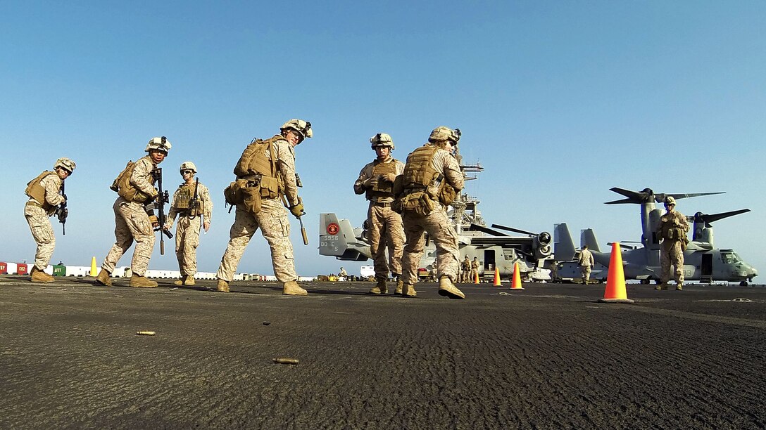 U.S. Marines assigned to Scout Sniper Platoon, Battalion Landing Team 3/2, 26th Marine Expeditionary Unit (MEU), conduct an M4 Carbine live-fire exercise on the flight deck of the USS Kearsarge, at sea, July 18, 2013. The 26th MEU is a Marine Air-Ground Task Force forward-deployed to the U.S. 5th Fleet area of responsibility aboard the Kearsarge Amphibious Ready Group serving as a sea-based, expeditionary crisis response force capable of conducting amphibious operations across the full range of military operations. (U.S. Marine Corps photo by Sgt. Christopher Q. Stone, 26th MEU Combat Camera/Released)