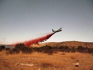 A view from ground firefighting crews as MAFFS 6 drops fire retardant to aid in the control of the Donaldson fire.  When full, the tanks being loaded hold 3,000 gallons of fire retardant. Established by Congress in the early '70s as a wildland fire protection program, MAFFS is a joint program with the Air National Guard, Air Force Reserve, and the U.S. Forest Service. 