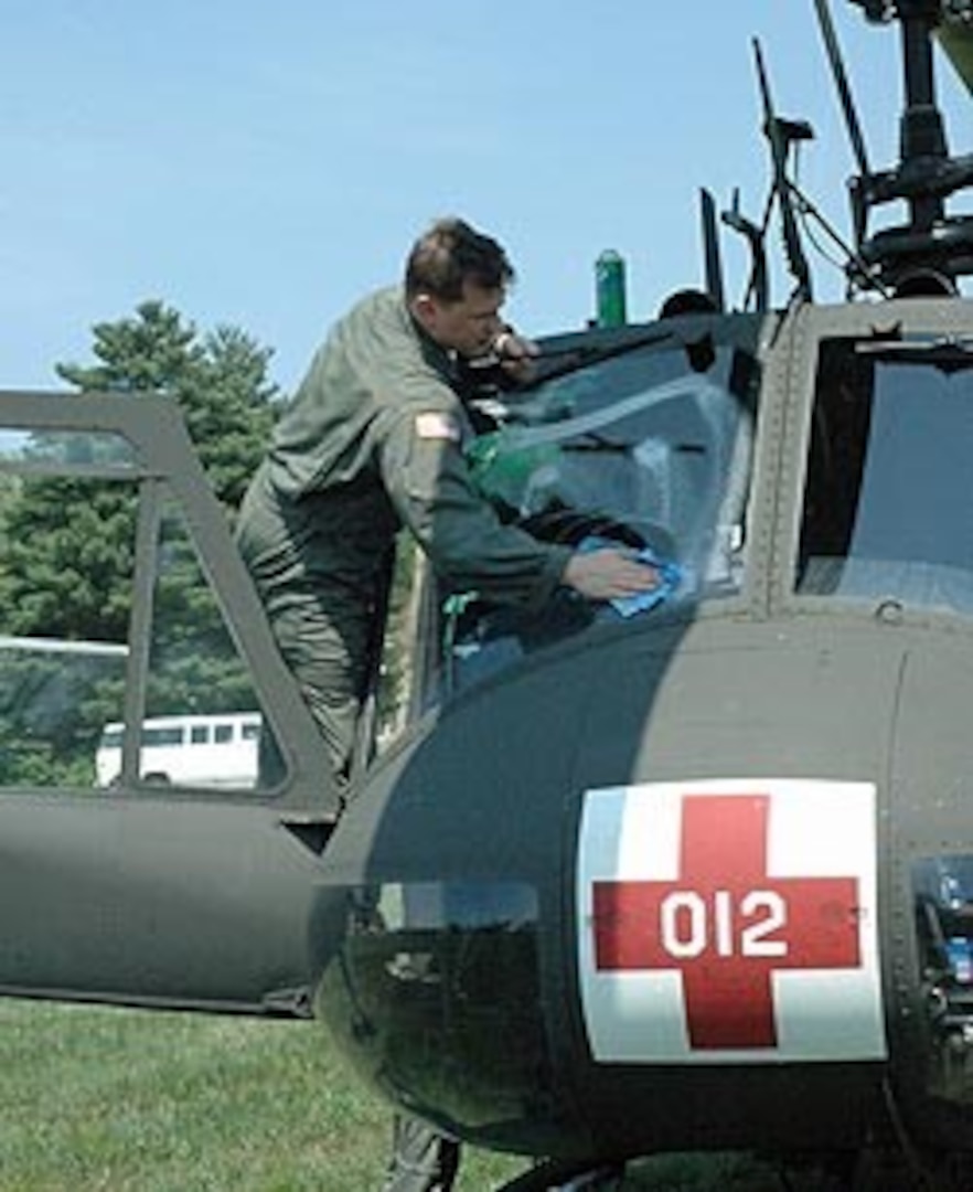 An aeromedical air crew member from the 121st Medical Company, District of Columbia Army National Guard, prepares a UH-1H helicopter at the Muscatatuck Urban Training Center, Butlerville, Ind., to provide medical support for the National Guard training exercise Vigilant Guard.
