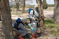Colorado Army National Guard Sgt. Ryan Betz, 8th Civil Support Team, works quickly to repair a tear in Sgt. Steve Russ's chemical suit during a Chemical, Biological, Radiological and Nuclear response exercise May 3, 2012, on the U.S. Air Force Academy. Russ's suit suffered a rupture during a simulated reconnaissance mission of a contaminated area, and Betz used tape to seal it before continuing with the mission. U.S. Army North, a subordinate of U.S. Northern Command, is responsible for evaluating CSTs every 18 months. 

