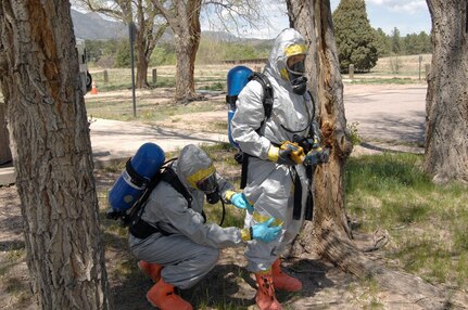 Colorado Army National Guard Sgt. Ryan Betz, 8th Civil Support Team, works quickly to repair a tear in Sgt. Steve Russ's chemical suit during a Chemical, Biological, Radiological and Nuclear response exercise May 3, 2012, on the U.S. Air Force Academy. Russ's suit suffered a rupture during a simulated reconnaissance mission of a contaminated area, and Betz used tape to seal it before continuing with the mission. U.S. Army North, a subordinate of U.S. Northern Command, is responsible for evaluating CSTs every 18 months. 
