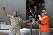 Air Force Reservist Senior Airman Barry Logan, 302nd Maintenance Squadron, and Tony Waiswilos, U.S. Forest Service, give the signal to stop pumping retardant into a Modular Airborne Firefighting System-equipped C-130 during a reloading and refueling stop at Peterson Air Force Base, Colo., June 28. A MAFFS equipped aircraft can hold 3,000 gallons of water or retardant and discharge it five seconds. 
