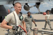 Senior Airmen Dustin Johannsen and Barry Logan pull a retardant hose from a MAFFS-equipped C-130 preparing to fly a drop mission in support of Colorado wildland fire fighting efforts June 29, here. MAFFS-equipped aircraft are capable of holding 3,000 gallons of retardant and can disperse it in five seconds. 
