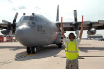 Airman Raymond DeSoto, 302nd Aircraft Maintenance Squadron, marshals a MAFFS-equipped C-130 at Peterson Air Force Base, Colo., June 29. MAFFS aircraft from the 302nd and 153rd Airlift Wings have been supporting Colorado wildland fire fighting efforts since June 25. 
