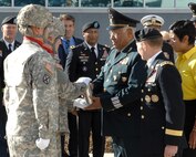 Members of the 3rd Battalion, 29th Field Artillery Regiment from Fort Carson, Colo., present Gen. Guillermo Galvan Galvan, Secretary of National Defense, Mexico, with an engraved artillery casing after honors were rendered to the general outside the Eberhart-Findley Building Oct. 19. The shell, along with a Mexican national flag flown in front of the NORAD and USNORTHCOM headquarters building, caps the end of Galvan’s last visit to the commands as Secretary of National Defense. His final two-day visit to Colorado Springs included a Modular Airborne Fire Fighting System demonstration by the 302nd Airlift Wing and visits with local community organizations. Galvan also took the opportunity to address a gathering of members of NORAD and USNORTHCOM where he discussed the vital relationship between the Mexican military and USNORTHCOM. Galvan is credited with enhancing the partnership between SEDENA and USNORTHCOM which is essential in the fight against transnational criminal organizations. This partnership in the counter-TCO mission is one of USNORTHCOM’s top priorities, and the command is committed to working together with the Mexican military against TCOs. Galvan steps down as Secretary of National Defense Dec. 1. 
