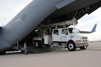 Staff Sgt. Jennifer Bartkus from the 161st Air Refueling Wing Aerial Port, Phoenix help guide a vehicle being loaded on a C-17 Globemaster III, Nov. 2, 2012.  The 161st ARW will facilitate the loading and transportation of Salt River Project and Arizona Public Service line crews, support staff and required vehicles in efforts to restore power in the aftermath of Hurricane Sandy.   (U.S. Air Force photo by Master Sergeant Kelly Deitloff/Released)