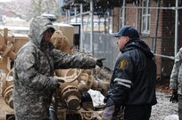 Sgt. Kimberly Boyce, water purification specialist, 401st Quartermaster Detachment, Lock Haven, Pa., discusses the best way to remove water out of a basement Nov. 7, 2012, with Carlos Malgonado, supervisor of grounds, Redfern Housing complex, Rockaway, N.Y. Residents at the complex have been without power since Hurricane Sandy hit the Northeast last week. Despite the effects of a second large storm, citizen-soldiers removed water from three buildings at the complex. The unit deployed into the area in direct support of the Federal Emergency Management Agency, state and local officials. 
