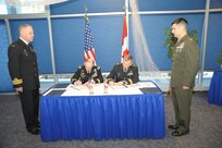 Army Gen. Charles Jacoby, Jr., commander of NORAD and U.S. Northern Command, and Lt.-Gen. Stuart Beare, Canadian Joint Operations Command commander, sign two significant documents - the Tri-Command Framework for Arctic Cooperation and the Tri-Command Training and Exercise Statement of Intent - during the 230th meeting of the Canada-U.S. Permanent Joint Board on Defense at the U.S. Air Force Academy in Colorado Springs, Colo. on Dec. 11, 2012. 
