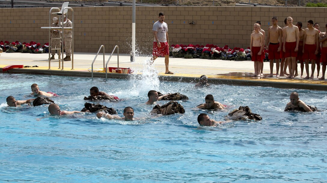 Devil Pups swim across the deep end of the 62-area swim tank pulling packs during one of their three pool sessions during the first increment of the Devil Pups Encampment 2013 held here July 7. The pool is a key part of the confidence-building regime the encampment employs, jumping from the 10-foot tower once and the 25-foot tower twice helps give the Devil Pups the confidence they desire. Devil Pups Inc. is a ten-day youth camp that teaches discipline and respect to teenagers age 14-17. 