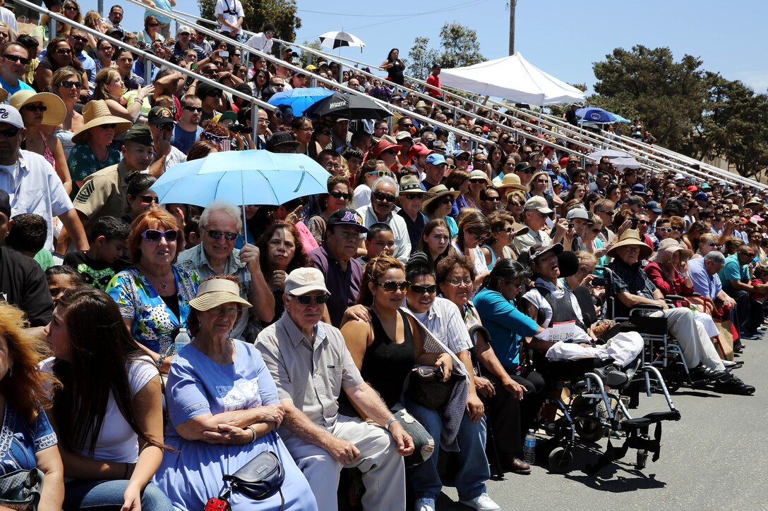 Family members watch as their teenagers march onto the 52-area parade deck on the day of their graduation from the Devil Pups Incorporated program held here July 13. Devil Pups Inc. encampments are a ten-day youth camp that teaches discipline and respect to teenagers age 14-17.