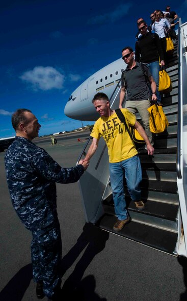 Rear Admiral John E. Jolliffe, U.S. 3rd Fleet deputy commander, greets Australian civilians and members of the Royal Australian Air Force as they deplane a KC-30 July 12, 2013, at Joint Base Pearl Harbor-Hickam, Hawaii, after arriving to support Talisman Saber 2013. Talisman Saber reflects the closeness of the U.S. and Australian alliance as well as the strength of the ongoing military-military relationship. Talisman Saber is a bilateral exercise designed to train Australian and U.S. forces in planning and conducting combined task force operations in order to improve combat readiness and interoperability. (U.S. Air Force photo by Staff Sgt. Nathan Allen)