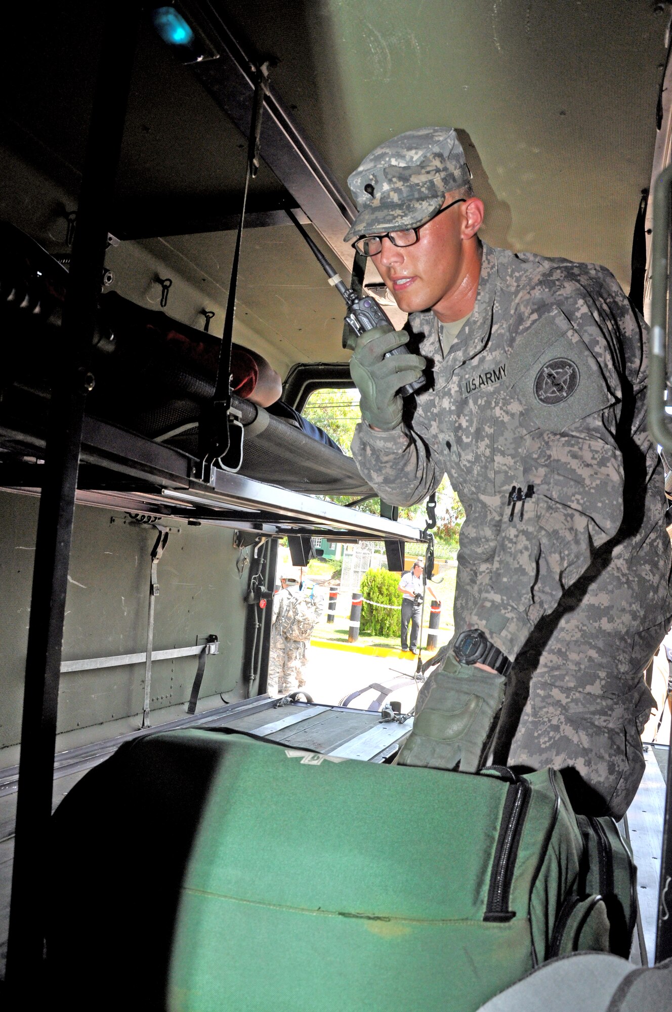 During a Honduran and American Anti-terrorism/Force protection exercise, here, U.S. Army Specialist Drew Danner, Joint Task Force-Bravo Medical Element emergency medical technician, notifies Medel he’s transporting patients and would need medical assistance, when a bomb was detonated during a protest at the front gate, July 17, 2013.  JTF-Bravo conducts Anti-terrorism/Force Protection exercise to ensure personnel readiness, which ensures service members are ready for real world events at a moment’s notice. (Photo released by U.S. Air Force Staff Sgt. Jarrod Chavana)