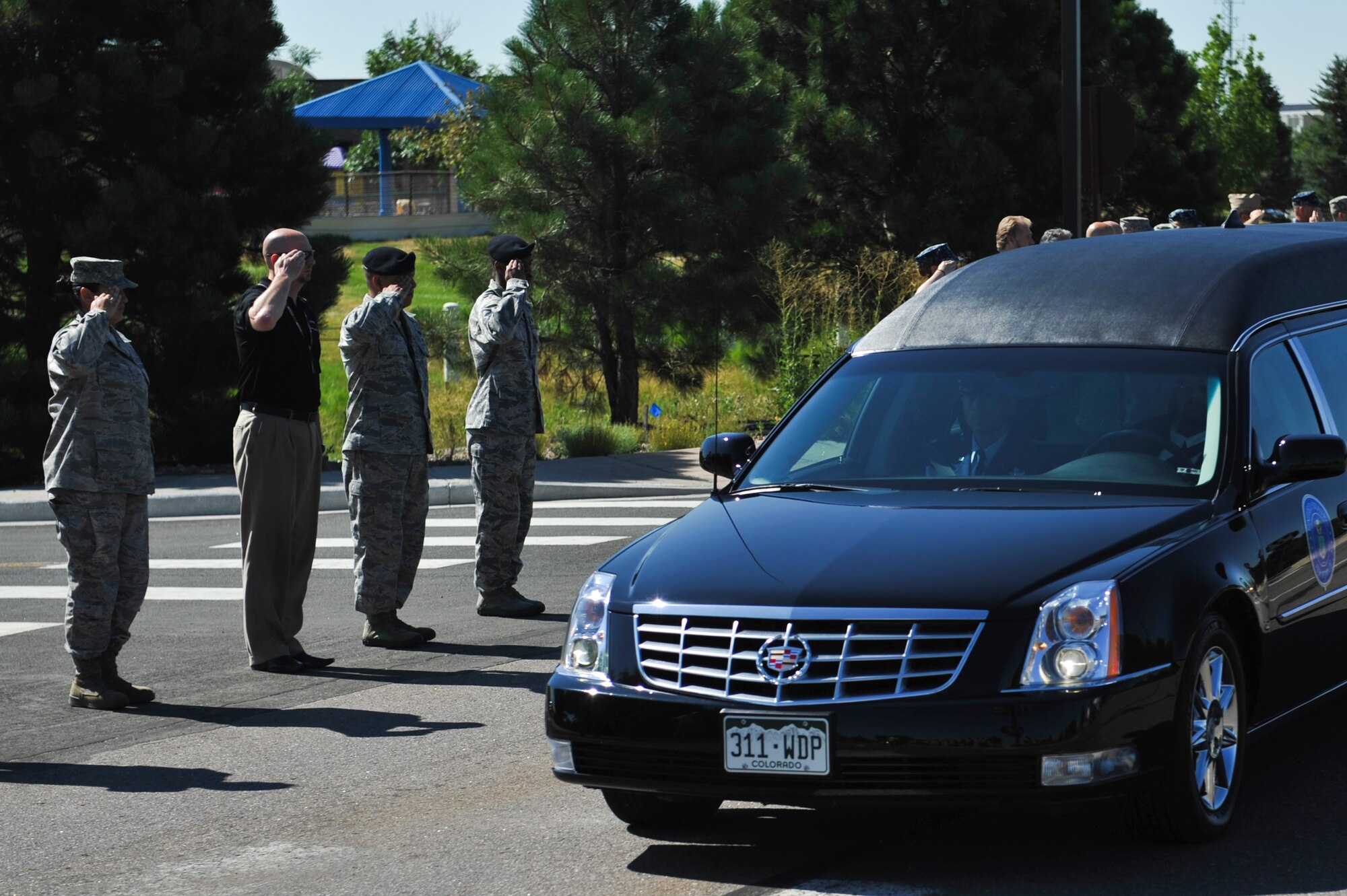Team Buckley members render a military courtesy to Airman 1st Class Shaquille Hargrove as he is transferred to Denver International Airport en route to his hometown of Wilson, N.C. July 18, 2013, Buckley Air Force Base, Colo. Hargrove, 2nd Space Warning Squadron satellite systems operator, was killed in an incident in downtown Denver July 13. (U.S. Air Force photo by Airman 1st Class Riley Johnson/Released) 