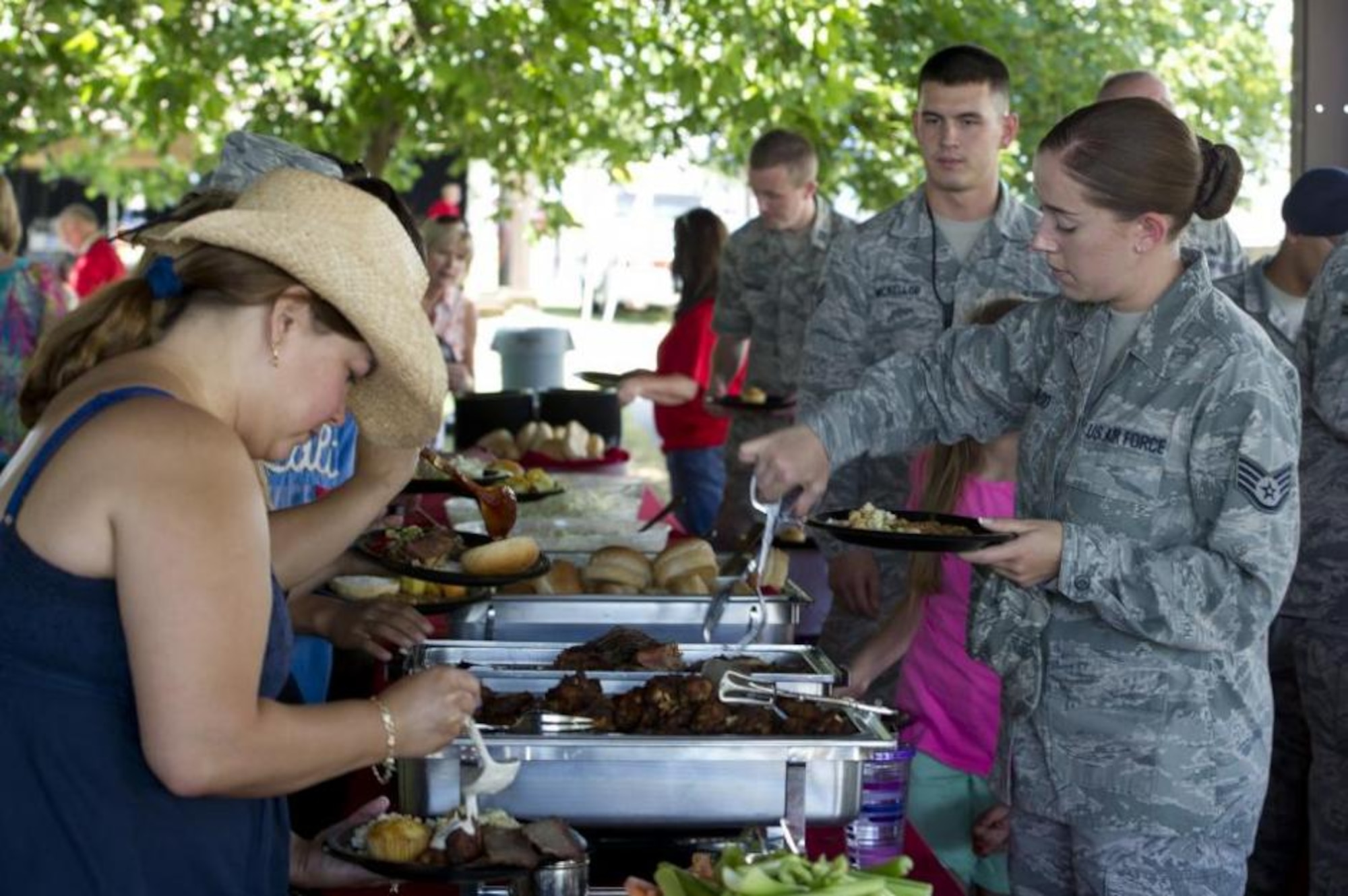 Team Hill members walk through the serving line at Centennial Park July 12. Gastronomy, along with other local food vendors, provided complimentary food, drinks, and desserts for military members and their families at the 2013 Salute to Our Nation's Defenders Picnic. (U.S. Air Force photo by Tech. Sgt. Eric Burks/Released)