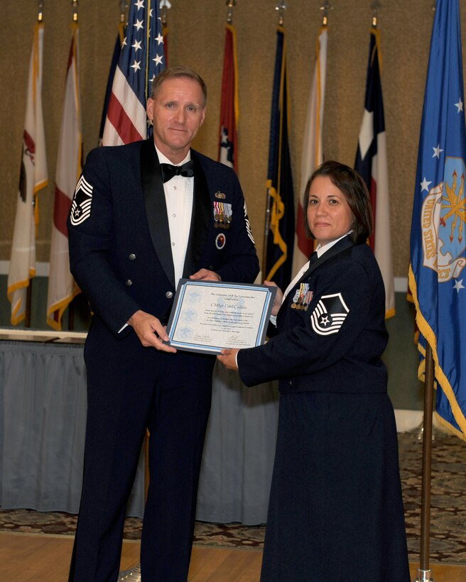 Chief Master Sgt. Carl Collins, Air National Guard Advisor to the Commander of Maxwell Air Force Base, receives a certificate of appreciation from Master Sgt. Maria Rodriguez. Rodriguez went through the last Senior Non-Commissioned Officer Induction Ceremony and had the opportunity to lead this year’s ceremony.