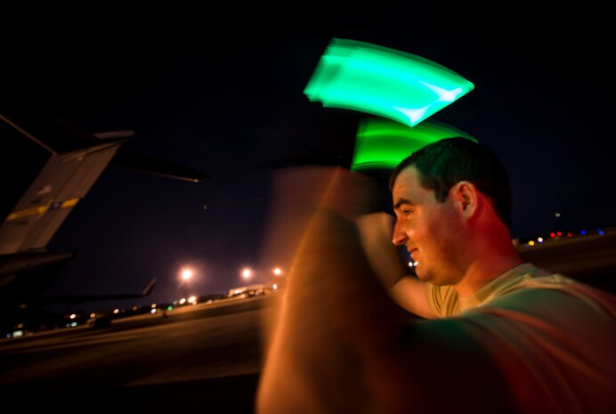 Senior Airman Joseph Goodman, 437th Aerial Port Squadron passenger terminal technician, marshals a Humvee off a C-17 Globemaster III while practicing combat on-loading and off-loading July 17, 2013, at Joint Base Charleston – Air Base, S.C. Airmen from the 437th Airlift Wing work around the clock on the flightline to provide combat-ready C-17A aircrews, mission support personnel and processes for 53 assigned aircraft to meet White House, Department of State and Joint Chiefs of Staff-directed global deployment, employment and resupply of Department of Defense and allied forces via air-land and airdrop operations. (U.S. Air Force photo/ Senior Airman Dennis Sloan)