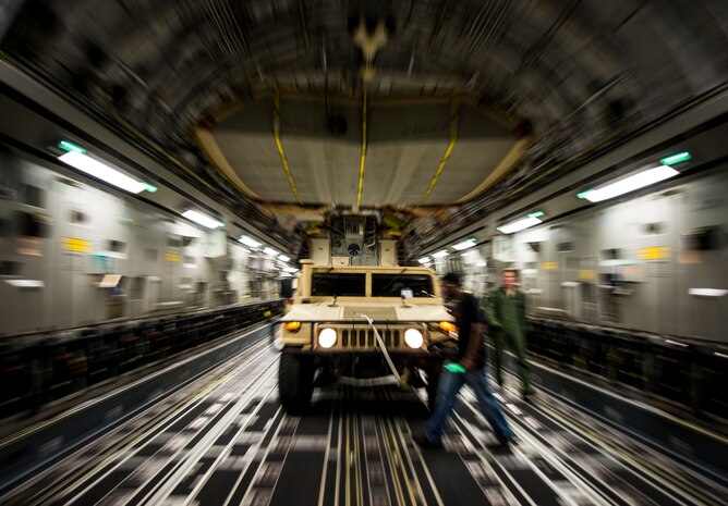 A Humvee is loaded onto a C-17 Globemaster III during an exercise to practice combat on-loading and off-loading July 17, 2013, at Joint Base Charleston – Air Base, S.C. Airmen from the 437th Airlift Wing work around the clock on the flightline to provide combat-ready C-17A aircrews, mission support personnel and processes for 53 assigned aircraft to meet White House, Department of State and Joint Chiefs of Staff-directed global deployment, employment and resupply of Department of Defense and allied forces via air-land and airdrop operations. (U.S. Air Force photo/ Senior Airman Dennis Sloan)