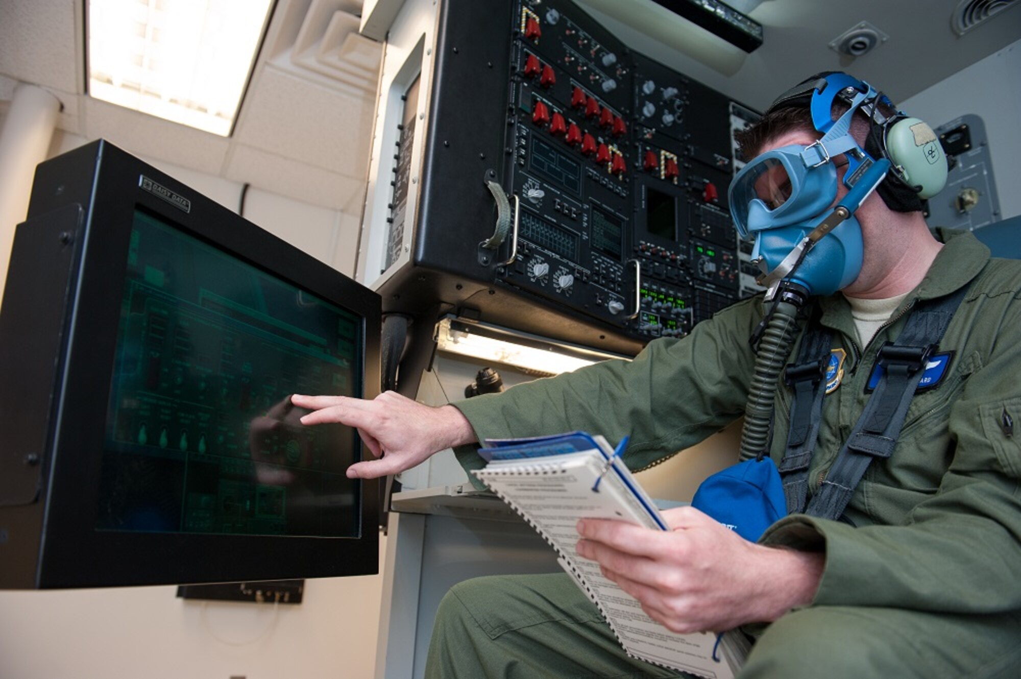 Staff Sgt. Nathan Girard, 6th Airlift Squadron loadmaster, dons his oxygen mask and reviews the emergency procedures in a C-17 Globemaster III simulator July 11, 2013, at Joint Base McGuire-Dix-Lakehurst, N.J. The simulated C-17 fuselage enables loadmasters to practice onboard emergencies including fire- and smoke-filled cabin senarios, in addition to combat offloads and night-vision goggle scenarios in a real-time environment.Girard hails from Berlin, N.H. (U.S. Air Force photo by Carlos Cintron/Released)