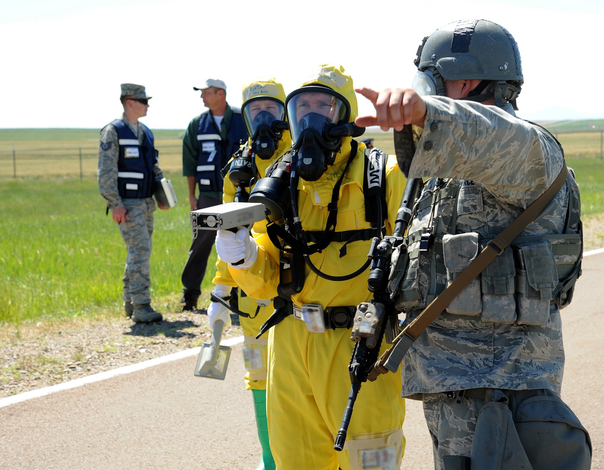 Malmstrom Air Force Base explosive ordnance disposal and security forces members discuss the scene of an exercise incident July 10 on Perimeter Road. Emergency responders are often the first to arrive at an incident scene and help to ensure the safety and security of those assigned to Malmstrom. (U.S. Air Force photo/Staff Sgt. R.J. Biermann)