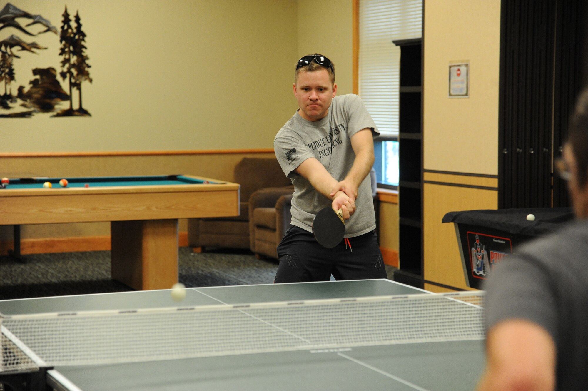 Capt. Luke Oman, 341st Operations Support Squadron ICBM weapons and tactics instructor, returns a serve to Capt. Nick Edwards, 341st OSS ICBM training products chief, during a pingpong  game at the Grizzly Bend during Wing Sports Smackdown on July 12. (U.S. Air Force photo/Airman 1st Class Collin Schmidt)
