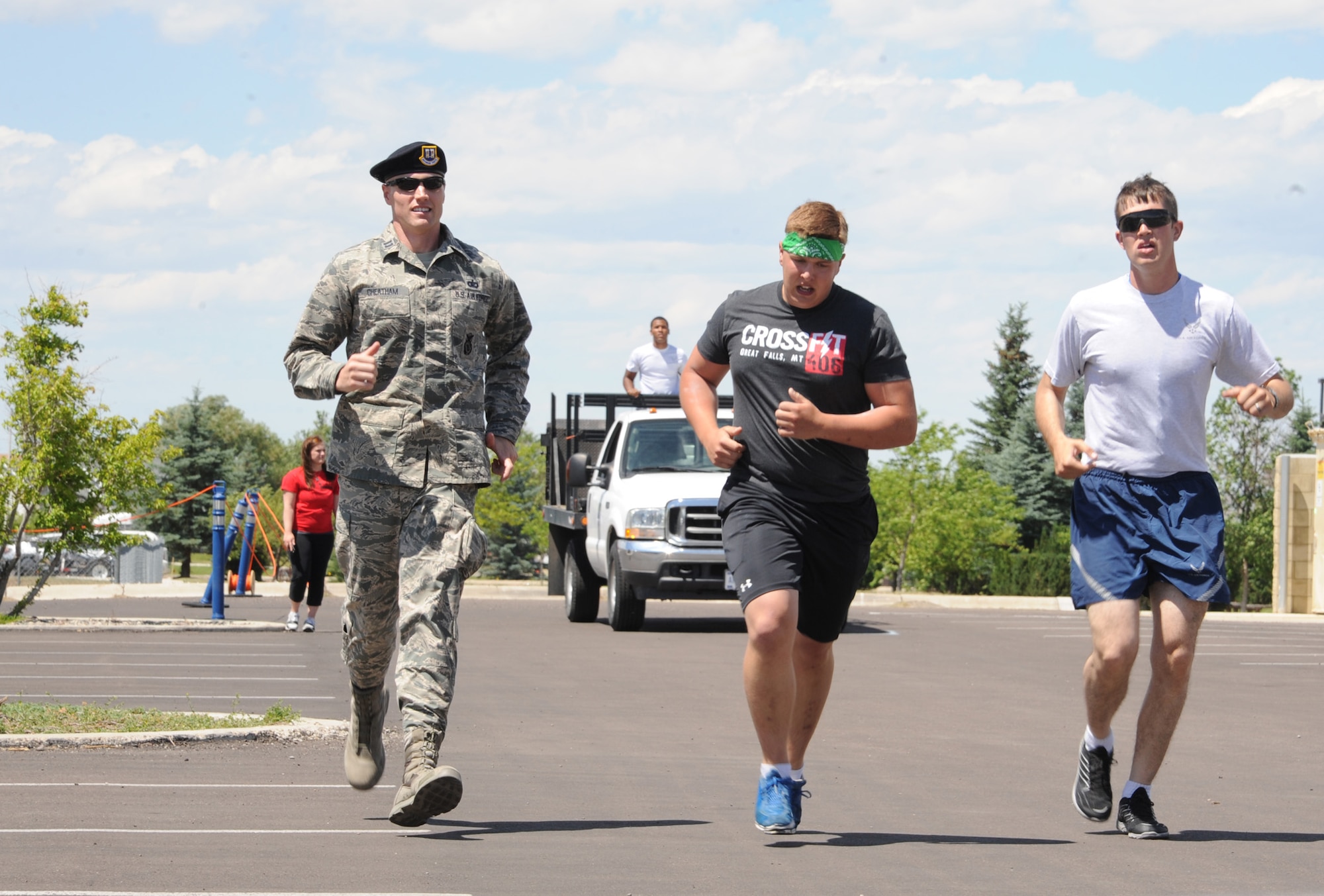 Capt. Michael Cheatham, 741st Missile Security Forces Squadron operations officer, (left) and Airman 1st Class Anthony Westberry, 341st Security Forces Squadron member, (right) pace with Senior Airman Rick Welty, 341st Security Forces Group tactical response force member, during the first station of the strongman competition at the Grizzly Bend on July 12. Airmen were tasked with carrying 180-pound kegs for a distance of 50 yards. (U.S. Air Force photo/Airman 1st Class Collin Schmidt)  