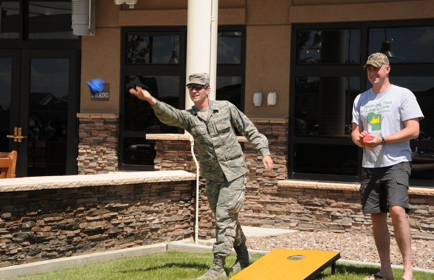 Airman 1st Class Jeff Hittle-Bottorff, 341st Civil Engineer Squadron engineering assistant, (left) and Tech. Sgt. Derek Wagner, 341st Missile Security Forces Squadron assistant flight chief, play a game of cornhole during Malmstrom’s quarterly Wing Sports Smackdown  event at the Grizzly Bend on July 12. Airmen had the opportunity to play many other games including pingpong , volleyball, basketball and more. (U.S. Air Force photo/Airman 1st Class Collin Schmidt) 