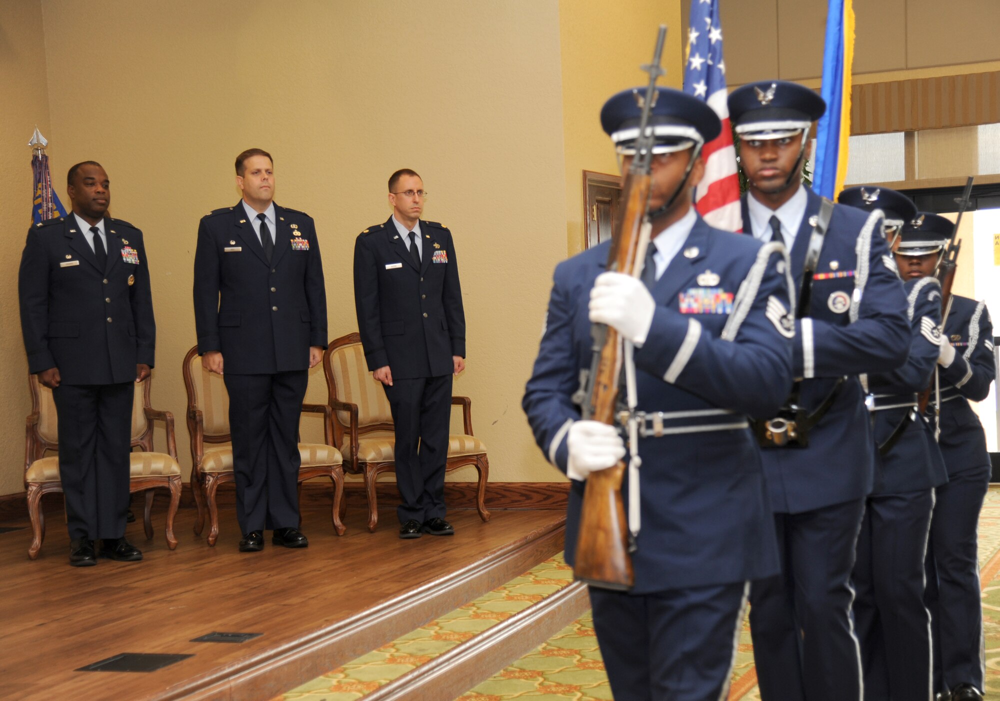 Col. Mark Vivians, 81st Mission Support Group commander; Lt. Col. Stephen Wier, outgoing 81st Logistics Readiness Squadron commander, and Maj. Cliff Bayne, incoming 81st LRS commander, stand at attention as the Keesler Honor Guard prepares to post the colors during a change of command ceremony July 18, 2013, at the Bay Breeze Event Center, Keesler Air Force Base, Miss.  (U.S. Air Force photo by Kemberly Groue)