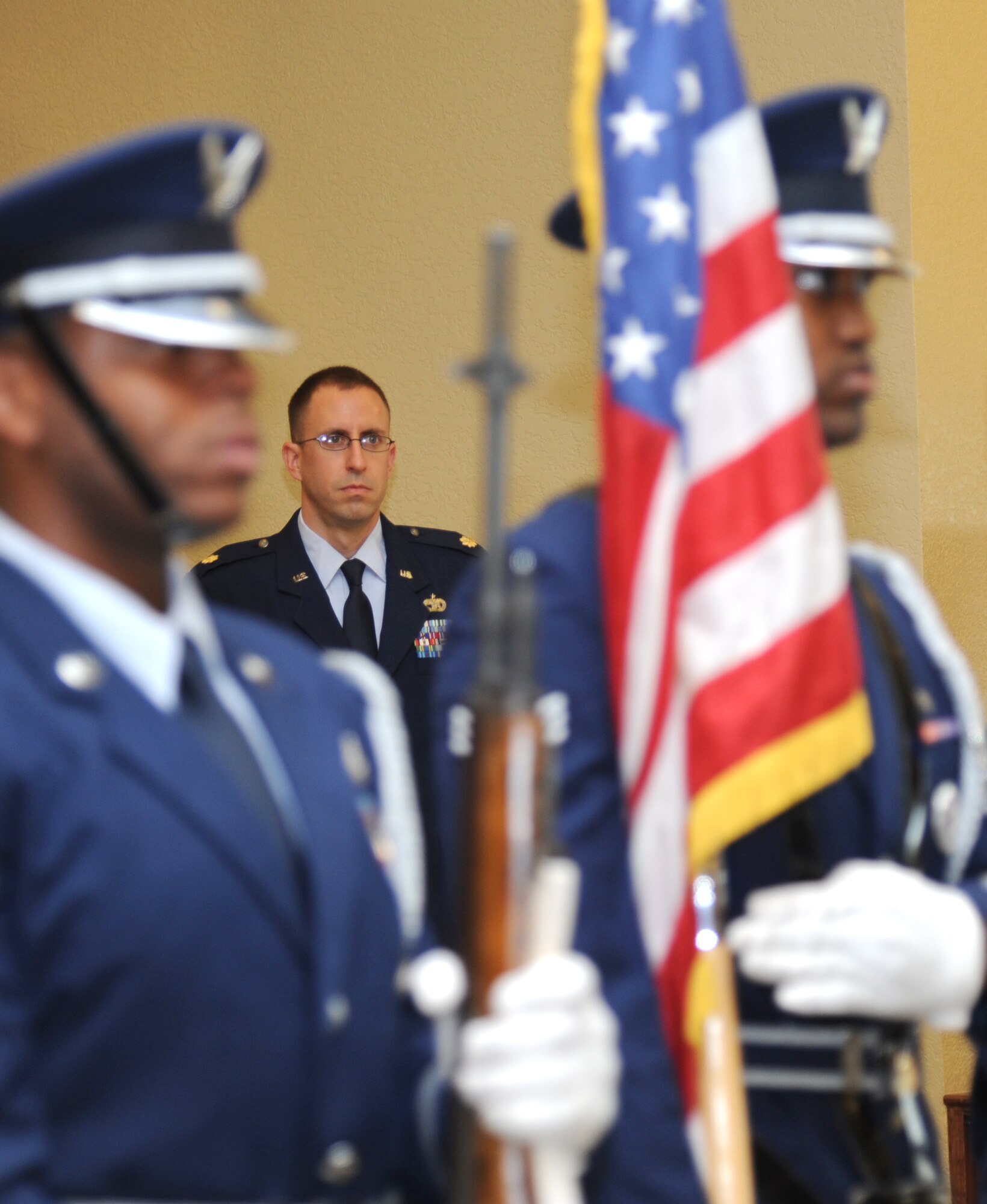 Maj. Cliff Bayne, incoming 81st Logistics Readiness Squadron commander, stands at attention as the Keesler Honor Guard prepares to post the colors during a change of command ceremony July 18, 2013, at the Bay Breeze Event Center, Keesler Air Force Base, Miss.  Col. Mark Vivians, 81st Mission Support Group commander, was the officiating officer for the event and Lt. Col. Stephen Wier was the outgoing 81st LRS commander.  (U.S. Air Force photo by Kemberly Groue)