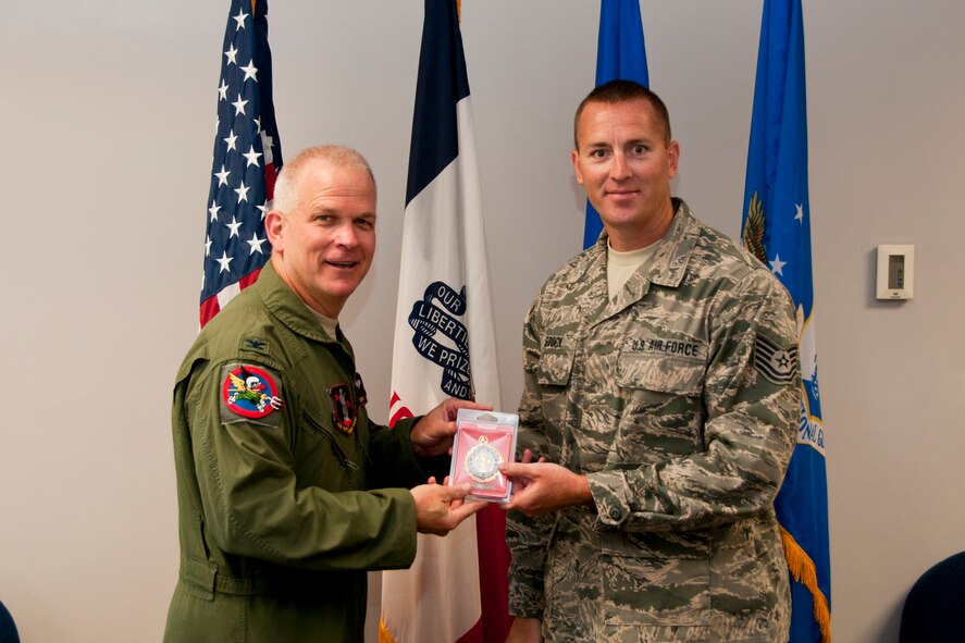 Col. William Dehaes, Commander 132nd Fighter Wing (132FW), Des Moines, Iowa, presents a gold recruitment badge to Tech. Sgt. Jason Stock on July 18, 2013. The 132nd recruitment and retention team was recognized as the best out of a nine-state region during FY12.   (U.S. Air National Guard photo by Senior Airman Dustin M. Smart/Released)