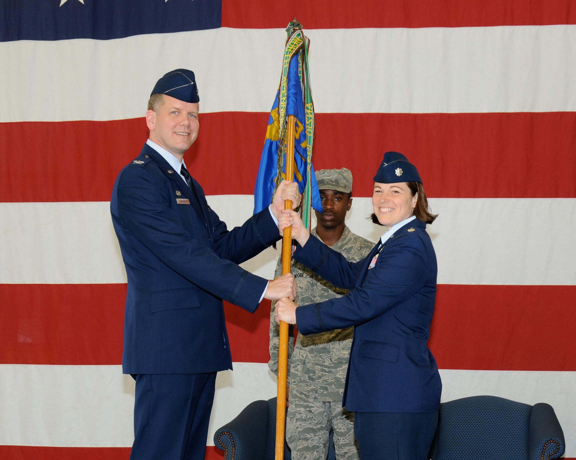 Col. Brett Pennington, 14th Operations Group Commander, hands the guidon to Lt. Col. Cheryl Ingber, the new 37th Flying Training Squadron Commander, at a change of command ceremony July 12 at the Fuels Maintenance Hangar. Ingber, who was previously in charge of Safety for the Wing Staff Agency, is taking command of the 37th FTS from Lt. Col. James Sparrow. (U.S. Air Force Photo/ Sharon Ybarra)