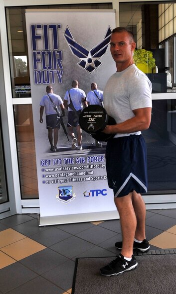 Senior Airman Brad Zemke, 2nd Aircraft Maintenance Squadron crew chief, poses in front of the new Fit for Duty sign at the Senior Airman Bell Fitness & Sports Center. The Air Force Personnel Center fitness and sports team has partnered with The Pentagon Channel to create the Fit for Duty initiative which takes viewers through a 30-minute workout led by service members with expertise in fitness training. (U.S. Air Force photo illustration/Airman 1st Class Benjamin Raughton)
