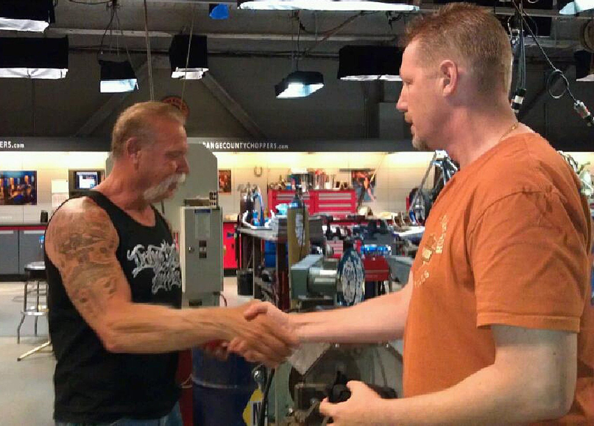 Paul Teutell Sr.  of Orange County Choppers shakes hands with Tom Steward, of the U.S. Army Support Activity Safety Office, after the presentation of a Joint Base McGuire Dix Lakehurst plaque and coin presentation July 11, 2013, in Newburgh, N.Y. The gifts recognized Tuetell's support for the U.S. military. Seventy riders participated in the experienced Motorcycle Mentorship ride. (U.S. Army courtesy photo/Released)