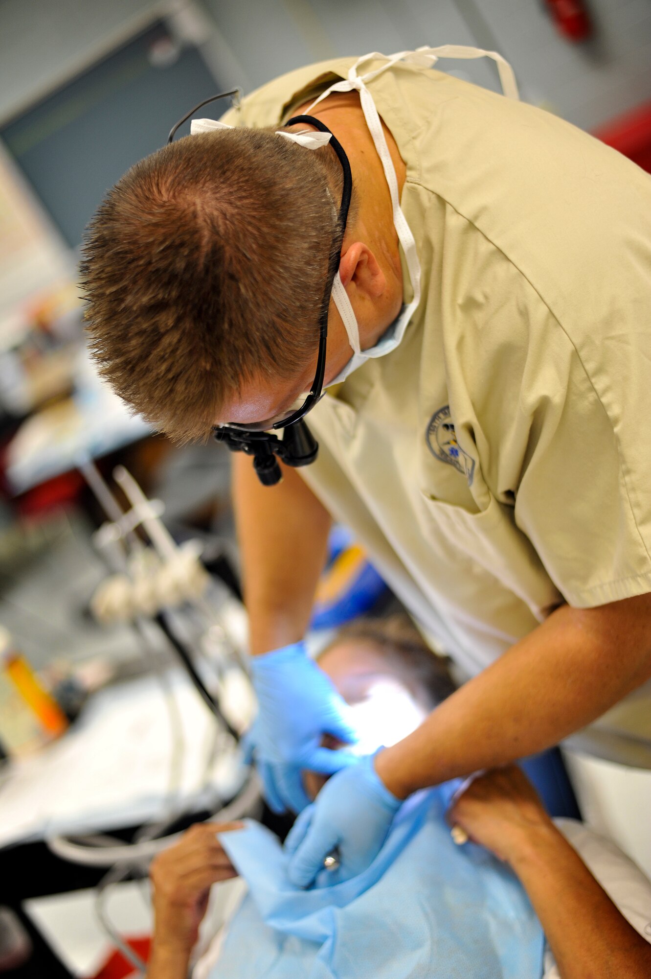 Lt. Col. Shawn Thompson, a dentist with the 180th Fighter Wing, Ohio Air National Guard, extracts a tooth July 15, 2013, at Martin Middle School in Martin, Tenn. Thompson and about 130 service members from the Air National Guard, Naval Reserves and the Army came together in the West Tenn. Community to provide free medical care as part of Innovative Readiness Training in support of “Hope of Martin.”  Air National Guard photo by Master Sgt. Beth Holliker (Released). 