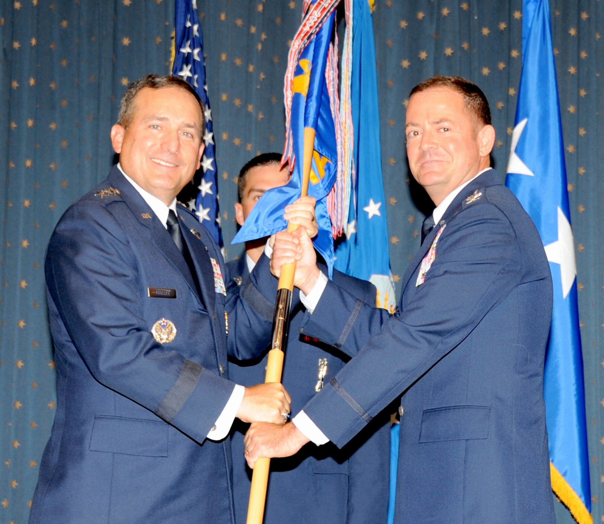 Lt. Gen. Stephen Mueller, Inspector General of the Air Force, passes the guidon to Col. Richard Coe, new Air Force Inspection Agency  commander at a change of command ceremony July 12. Most recently, Coe served as chief of staff at Pacific Air Forces Command, headquartered at Hickam Air Force Base, Hawaii. (Photo by Dennis Carlson)