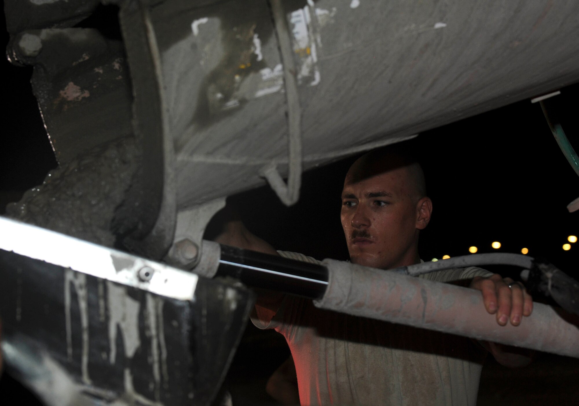 Staff Sgt. Bradley Schrage holds a discharge shoot on a cement truck steady as it pours wet concrete into concrete pump truck at the 379th Air Expeditionary Wing in Southwest Asia, July 9, 2013. Schrage is a 557th Expeditionary RED HORSE Squadron horizontal heavy repairs craftsman deployed from Malstrom Air Force Base, Mont. (U.S. Air Force photo/Senior Airman Bahja J. Jones) 