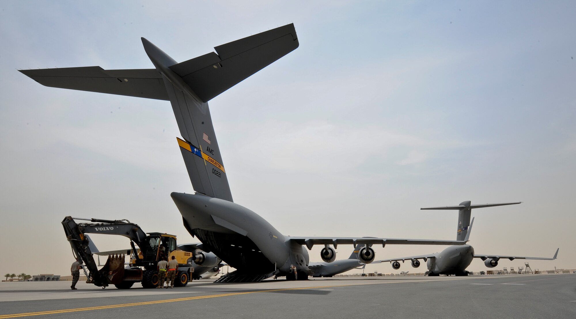 Airmen from the 8th Expeditionary Air Mobility Squadron and 557th Expeditionary RED HORSE Squadron load an excavator onto a C-17 Globemaster III at the 379th Air Expeditionary Wing in Southwest Asia, July 17, 2013. The C-17 will fly the heavy equipment to a forward operating location in Afghanistan where 1st Expeditionary Civil Engineer Group units will use it to support ongoing Operation Enduring Freedom missions. (U.S. Air Force photo/Senior Airman Benjamin Stratton)