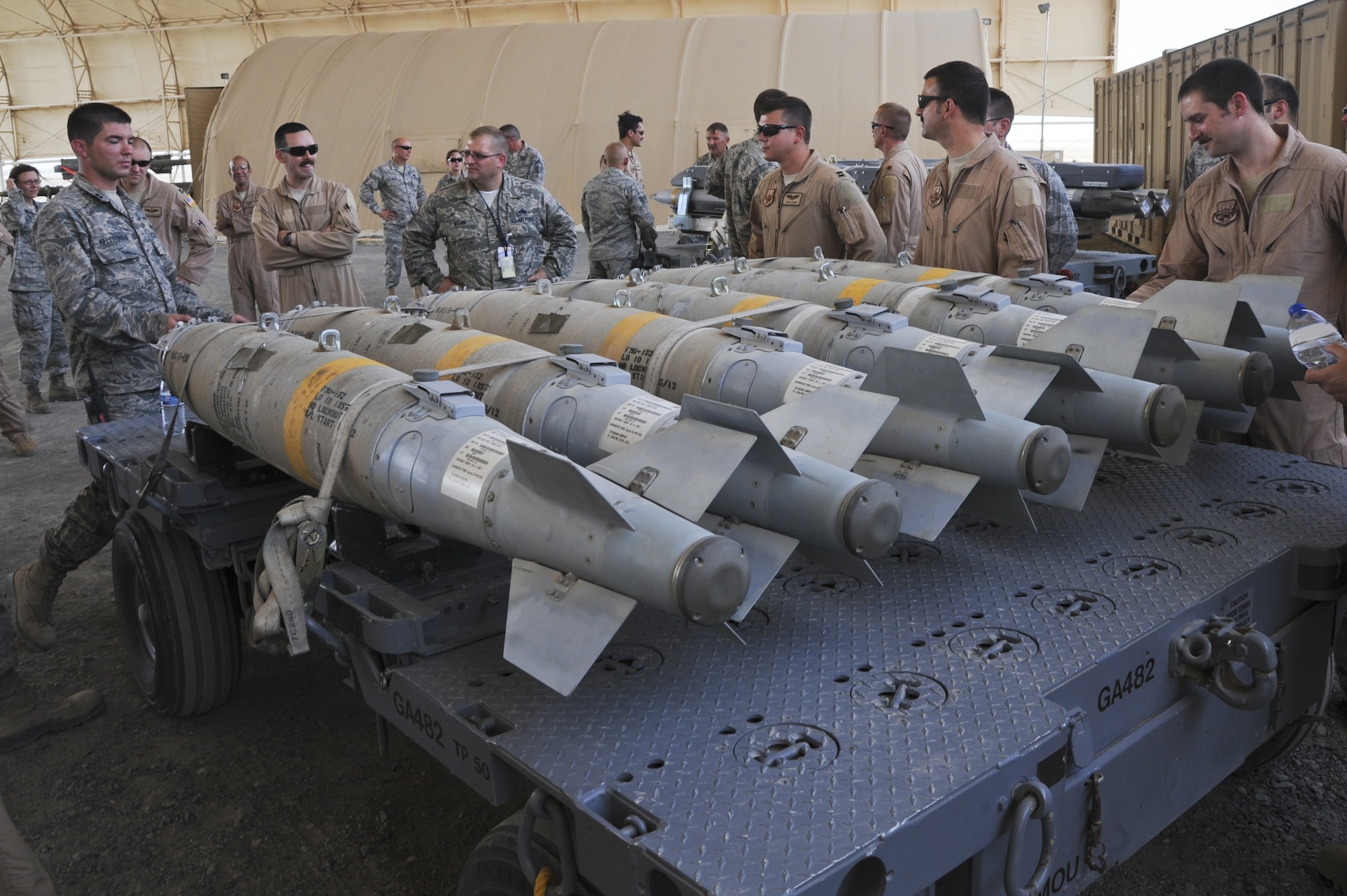 U.S. Air Force Capt. Patrick Kellerman, left, 380th Expeditionary Maintenace Squadron munitions flight chief, explains the low collateral capabilities of the GBU-38 version four to pilots of the 380th Air Expeditionary Wing at the temporary munitions storage area in an undisclosed location in Southwest Asia July 15, 2013. The bomb has only 27 pounds of explosive material and is used for precision targets where a small blast is needed. The pilots took a tour of the temporary munitions storage area in the hopes of gaining more knowledge of what goes into building munitions. Kellerman calls Fayetville, Ga., home and is deployed from Joint Base Elmendorf-Richardson, Alaska. (U.S. Air Force photo by Senior Airman Jacob Morgan)