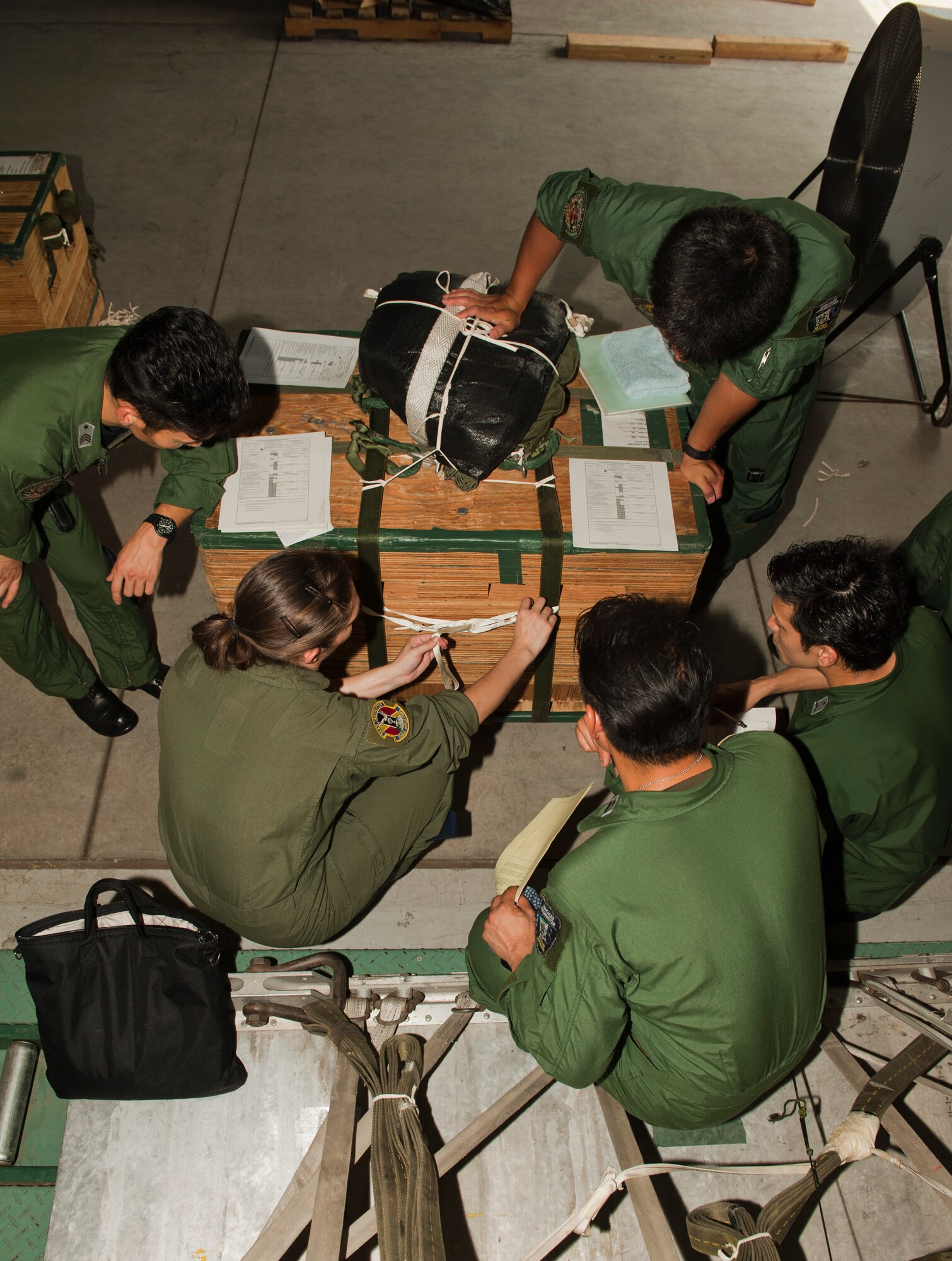 Staff Sgt. Monica Oshin, 36th Airlift Squadron, shows members of the Japan Air Self-Defense Force how to secure a container delivery system cargo load at Yokota Air Base, Japan, July 12, 2013. This type of cargo uses a high-velocity parachute, which have manufactured holes in them that help stabilize the load as it drops. (U.S. Air Force photo by Senior Airman Michael Washburn) 