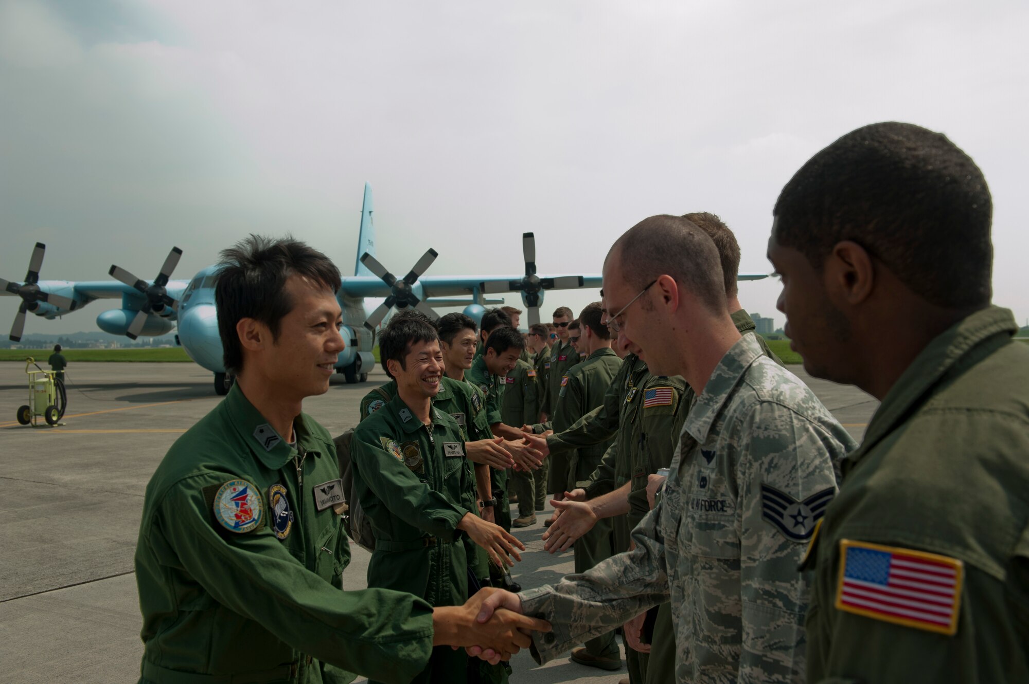 Japan Air Self-Defense Force members meet with Airmen from the 36th Airlift Squadron on the flightline at Yokota Air Base, Japan, July 12, 2013. JASDF loadmasters were able to see similarities and differences in Air Force cargo operations compared to their own. (U.S. Air Force photo by Senior Airman Michael Washburn)