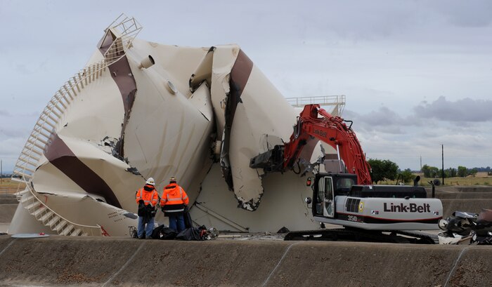 Demolition crews work on dismantling a 400,000 gallon fuel tank at Beale Air Force Base, Calif., June 24, 2013. The tanks were used as high-capacity fuel storage for the SR-71 Blackbird. (U.S. Air Force photo by Staff Sgt. Robert M. Trujillo/Released)