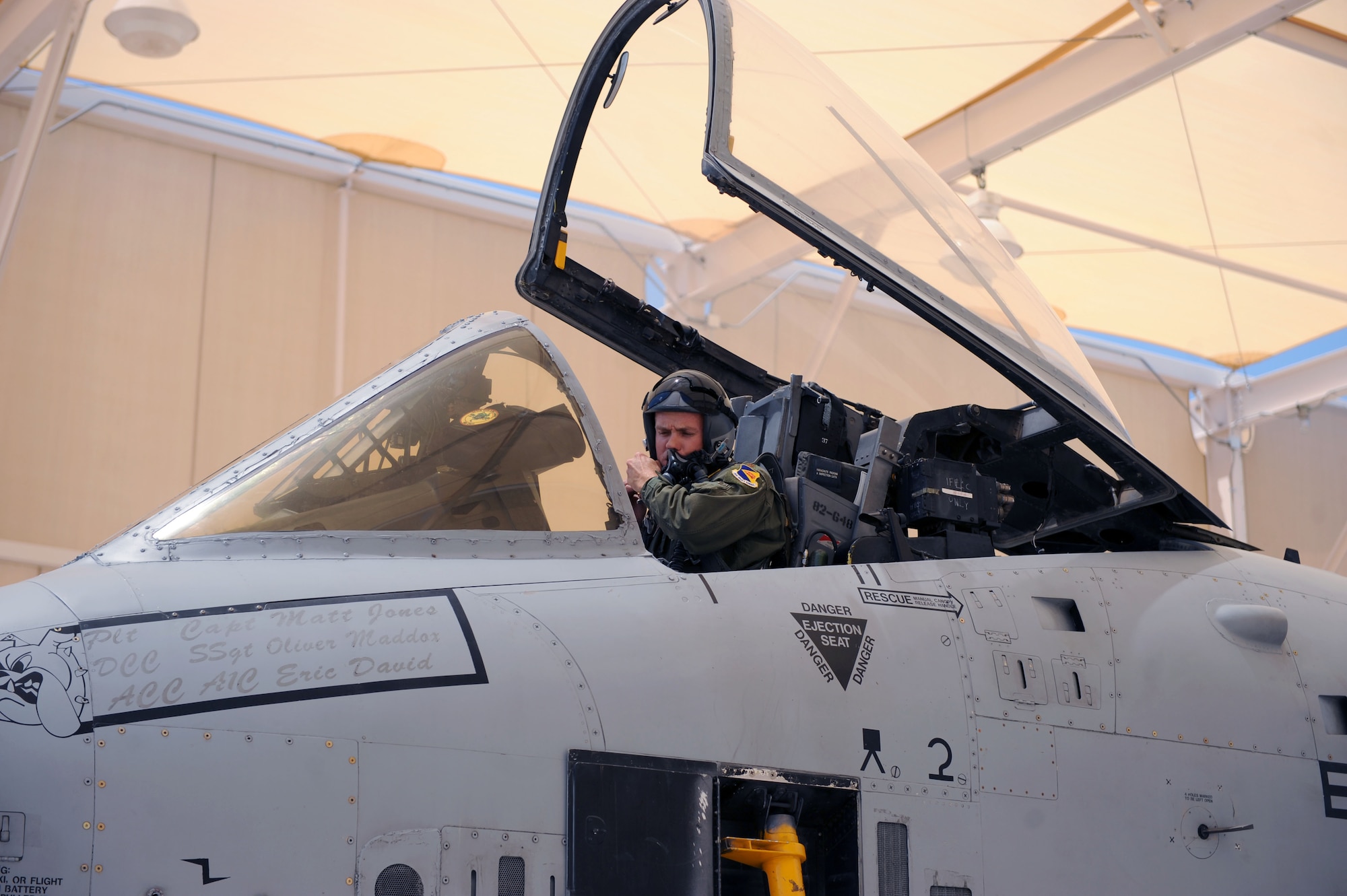 Maj. Dennis Hargis, 354th Fighter Squadron fighter pilot, adjusts the fit of his helmet as he sits in his aircraft at Davis-Monthan Air Force Base, Ariz., July 17, 2013.  The 354th FS recently resumed flying operations after a three-month, sequestration caused stand-down. (U.S. Air Force photo by Airman 1st Class Saphfire Cook/Released)