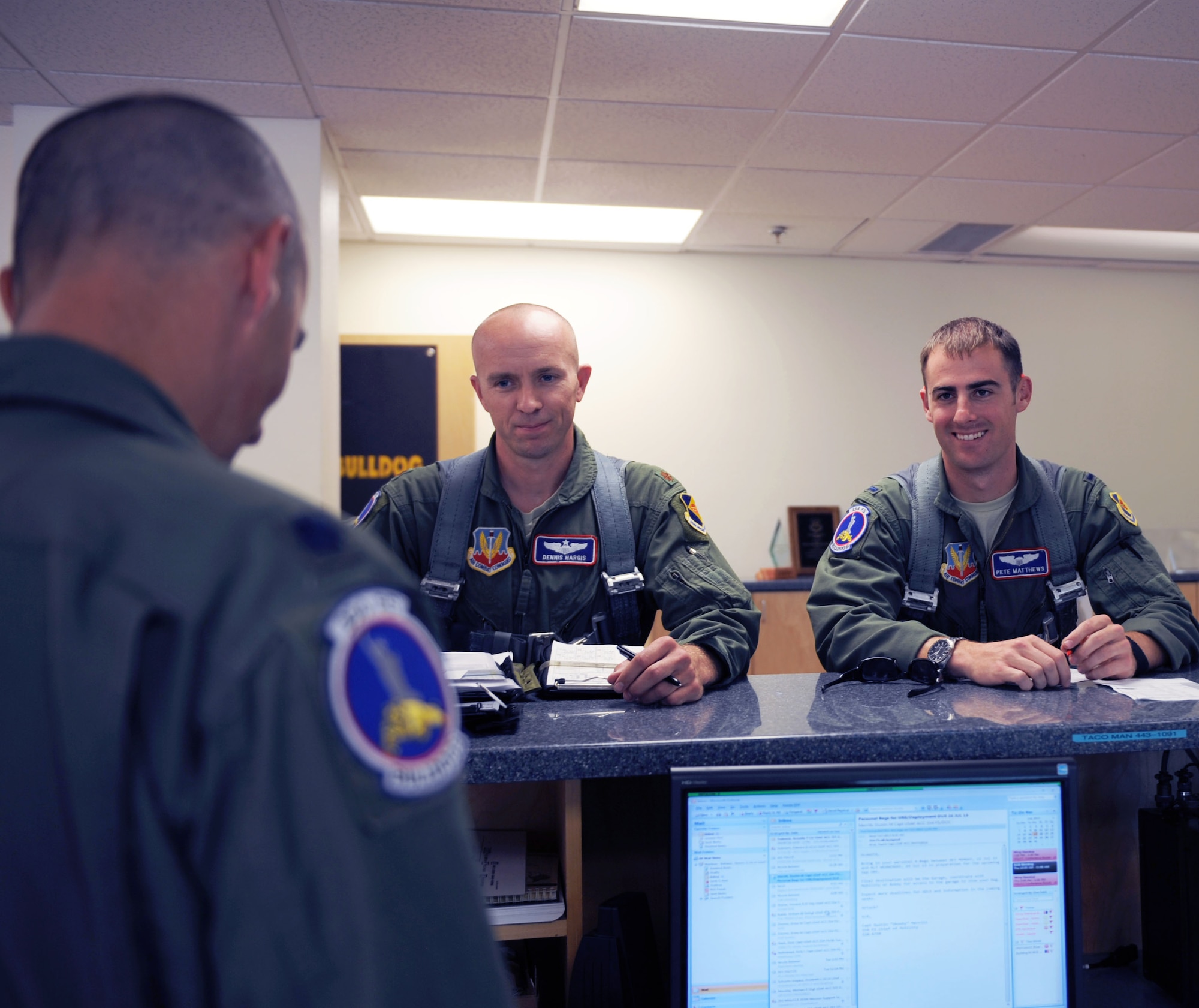 Maj. Dennis Hargis and 1st Lt. Pete Matthews, fighter pilots with the 354th Fighter Squadron, receive a preflight brief at Davis-Monthan Air Force Base, Ariz., July 17, 2013. Before a flight, pilots usually don their flight gear, grab their saddle bag, receive a briefing and then head out to the aircraft. This was one of the squadron's first flights following three months of grounding due to sequestration. (U.S. Air Force photo by Airman 1st Class Saphfire Cook/Released)