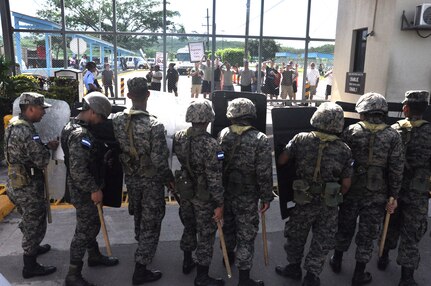 During a Joint Task Force-Bravo Anti-terrorism/Force protection exercise, here, U.S. service members posed as Honduran protesters holding up signs saying, “Go home,” as Honduran security forces were prepared for escalating protest July 17, 2013. JTF-Bravo conducts Anti-terrorism/Force Protection exercise to ensure personnel readiness, which ensures service members are ready for real world events at a moment’s notice. (Photo released by U.S. Air Force Staff Sgt. Jarrod Chavana)