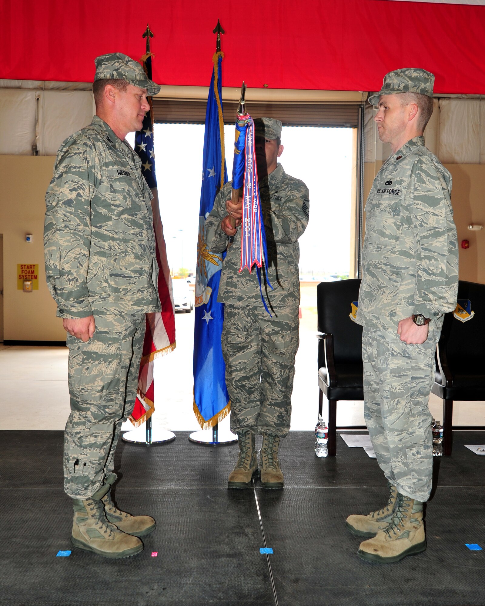 U.S. Air Force Col. David Wiesner, 27th Special Operations Maintenance Group commander, and Maj. Clifford Scruggs, 27th Special Operations Maintenance Operations Squadron commander, look on as the 27 SOMOS flag is furled during a ceremony at Cannon Air Force Base, N.M., July 18, 2013. The squadron stood down as part of an Air Force-wide restructuring initiative to better allocate company and field grade officers to necessary positions. (U.S. Air Force photo/Senior Airman Whitney Tucker)
