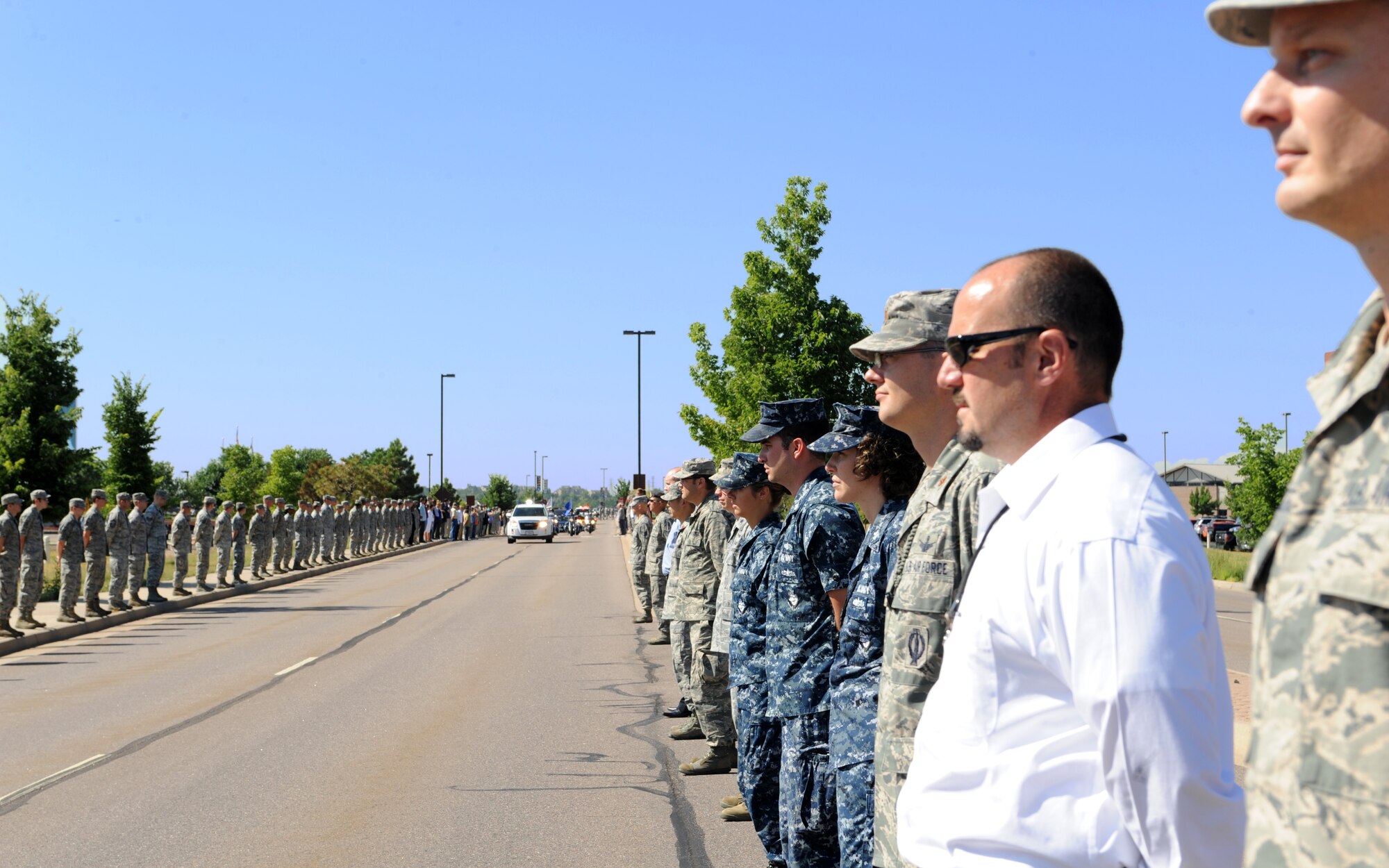 Members of Team Buckley line the street to render a final military courtesy to Airman 1st Class Shaquille Hargrove July 18, 2013, at Buckley Air Force Base, Colo. Hargrove was a satellite systems operator with the 2nd Space Warning Squadron. Hargrove was killed in an incident at 15th and Market Streets in downtown Denver July 13. (U.S. Air Force photo by Senior Airman Marcy Glass/Released) 